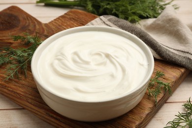 Photo of Tasty sour cream and dill on white wooden table, closeup