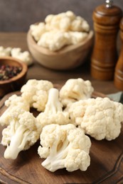 Photo of Fresh raw cauliflower florets and spices on table, closeup