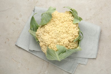 Photo of Fresh cauliflower with green leaves on light grey table, top view
