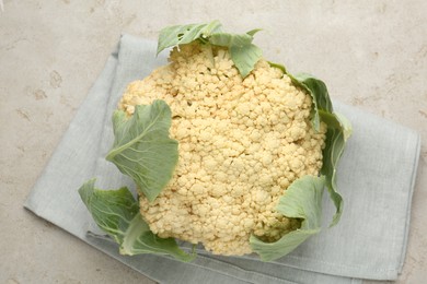 Photo of Fresh cauliflower with green leaves on light grey table, top view