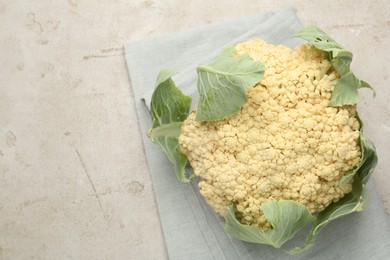 Photo of Fresh cauliflower with green leaves on light grey table, top view. Space for text