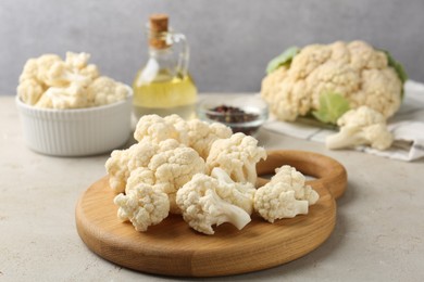 Photo of Fresh raw cauliflower florets and spices on light grey table, closeup