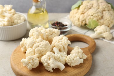 Photo of Fresh raw cauliflower florets and spices on light grey table, closeup
