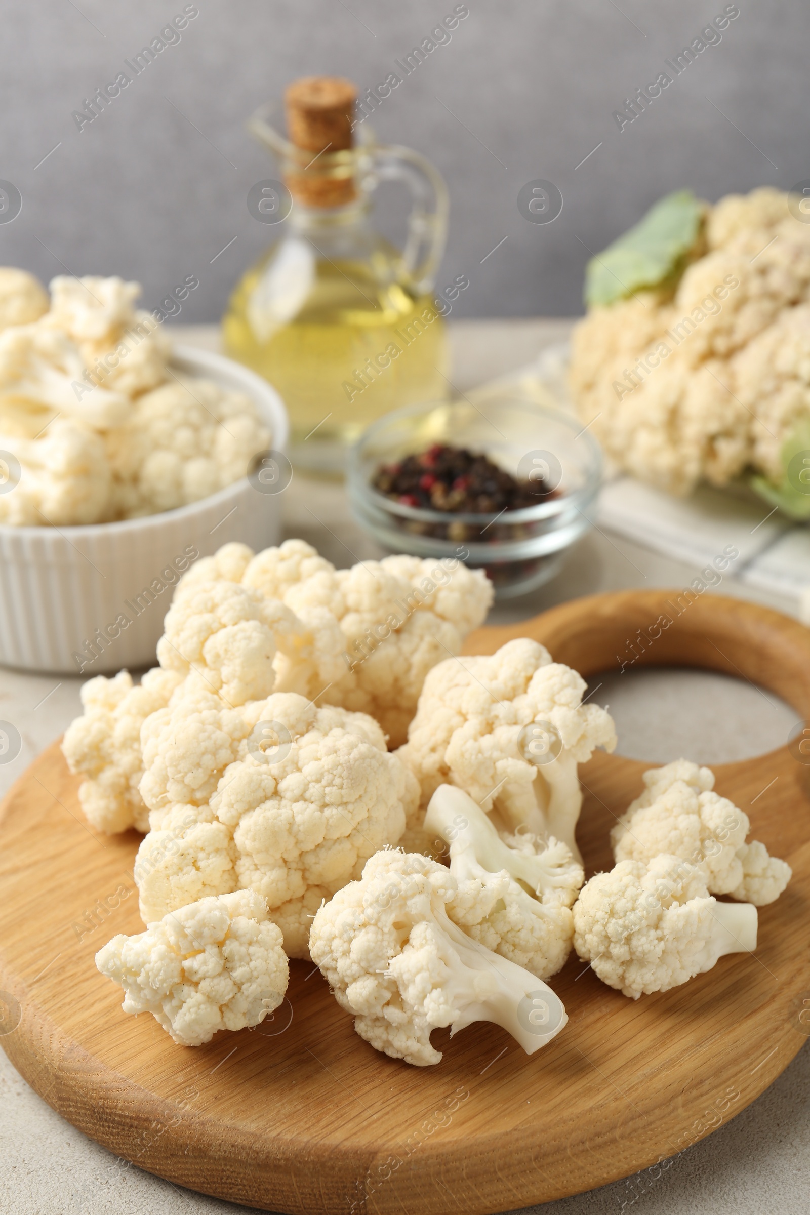 Fresh raw cauliflower florets and spices on light grey table, closeup Photo of Fresh raw cauliflower florets and spices on light grey table, closeup