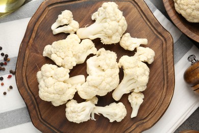 Photo of Fresh raw cauliflower florets and spices on table, flat lay