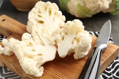 Photo of Fresh raw cauliflower florets and knife on table, closeup