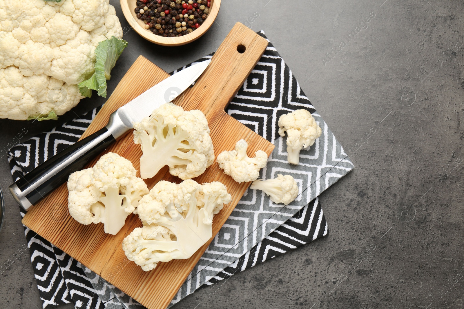 Fresh raw cauliflower florets, spices and knife on grey table, flat lay. Space for text Photo of Fresh raw cauliflower florets, spices and knife on grey table, flat lay. Space for text
