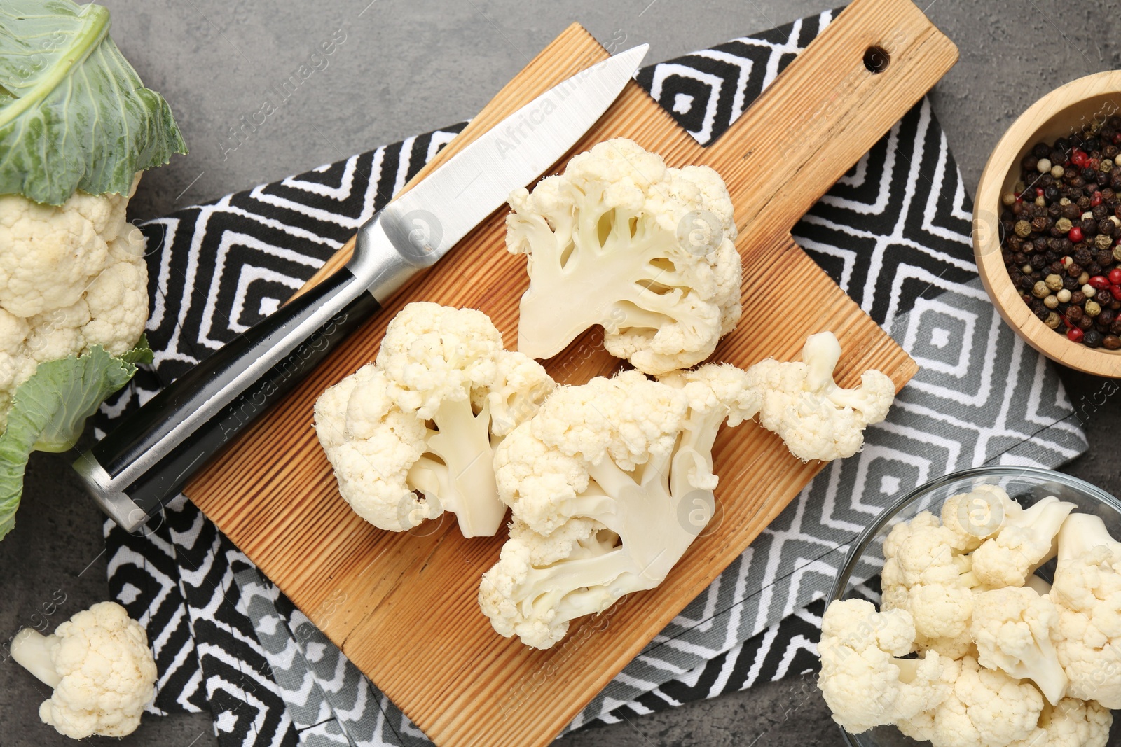 Fresh raw cauliflower florets, spices and knife on grey table, flat lay Photo of Fresh raw cauliflower florets, spices and knife on grey table, flat lay