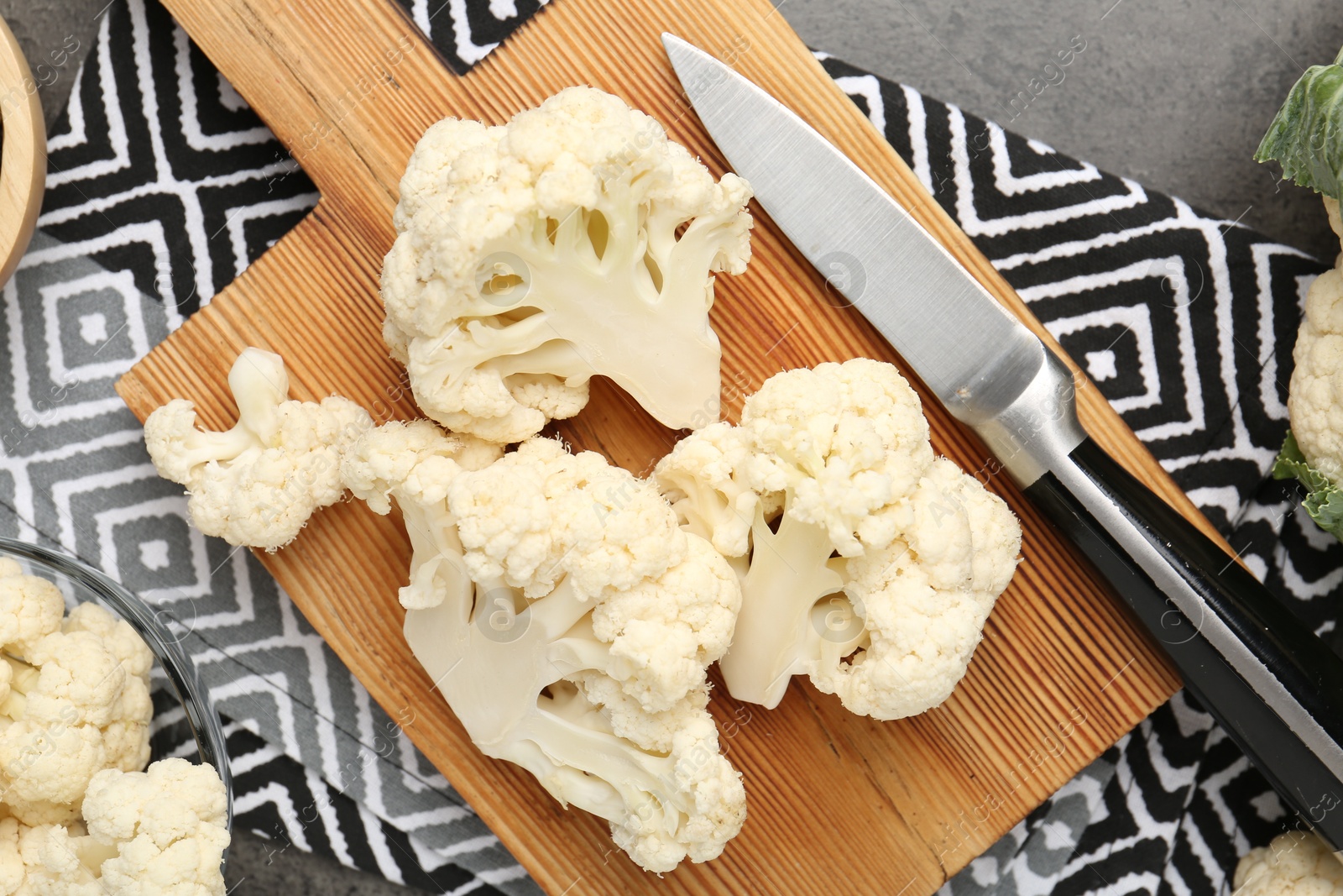 Fresh raw cauliflower florets and knife on grey table, flat lay Photo of Fresh raw cauliflower florets and knife on grey table, flat lay