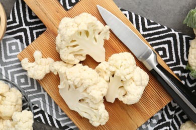 Photo of Fresh raw cauliflower florets and knife on grey table, flat lay