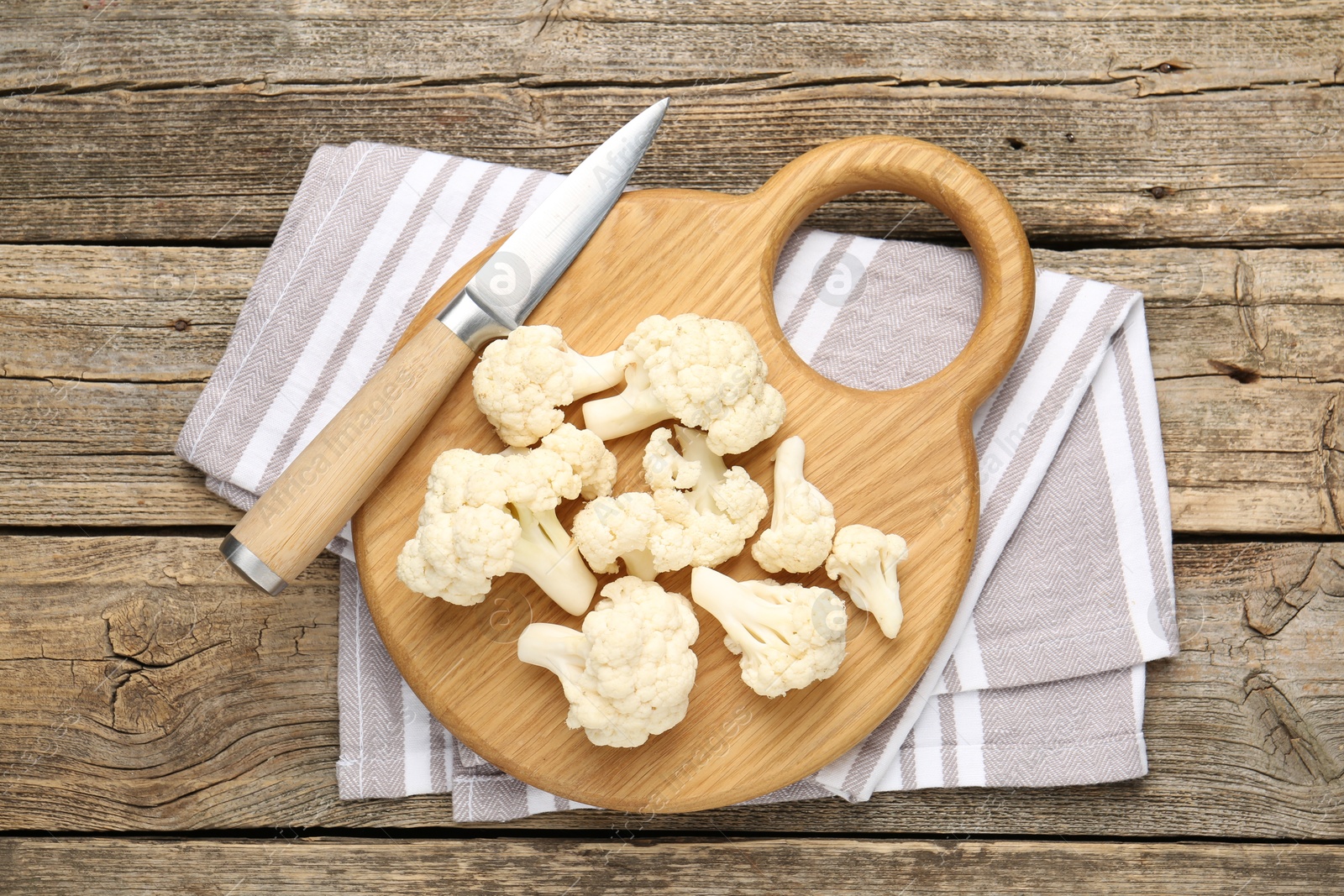 Fresh raw cauliflower florets and knife on wooden table, top view Photo of Fresh raw cauliflower florets and knife on wooden table, top view