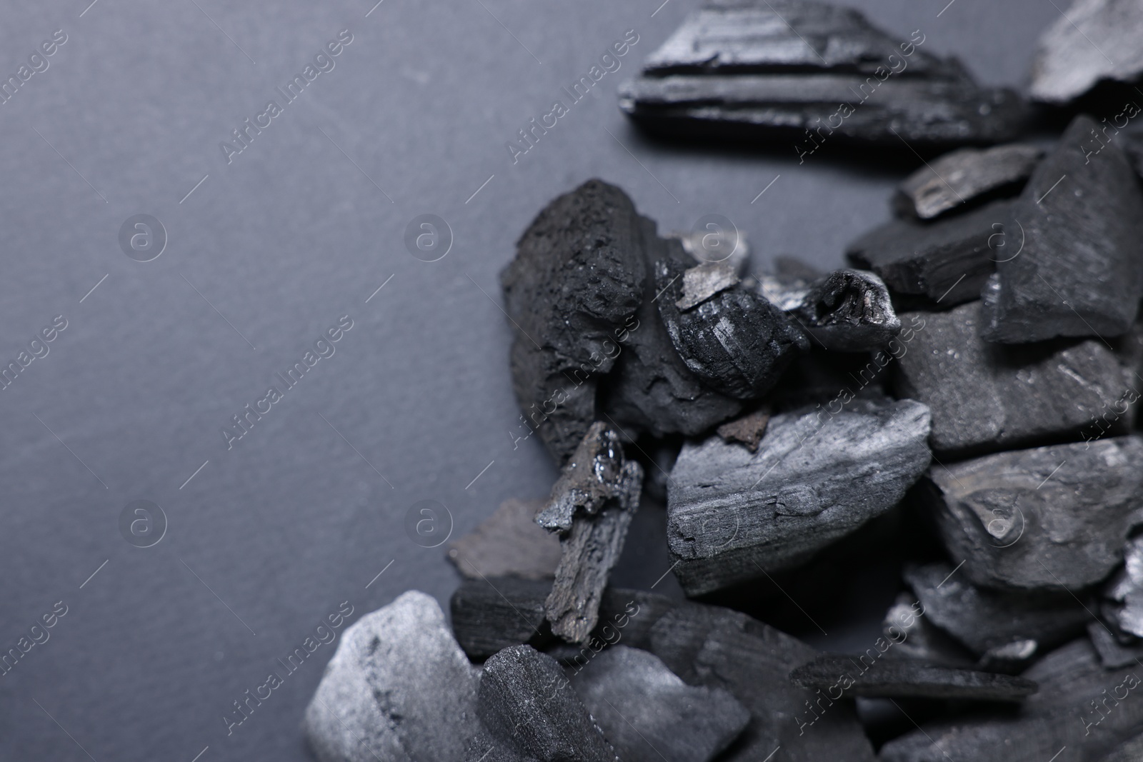 Pieces of black coals on grey background, top view. Space for text Photo of Pieces of black coals on grey background, top view. Space for text
