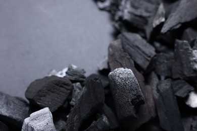 Photo of Pieces of black coals on grey background, closeup. Space for text