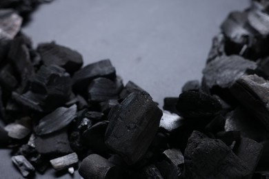 Photo of Pieces of black coals on grey background, closeup. Space for text