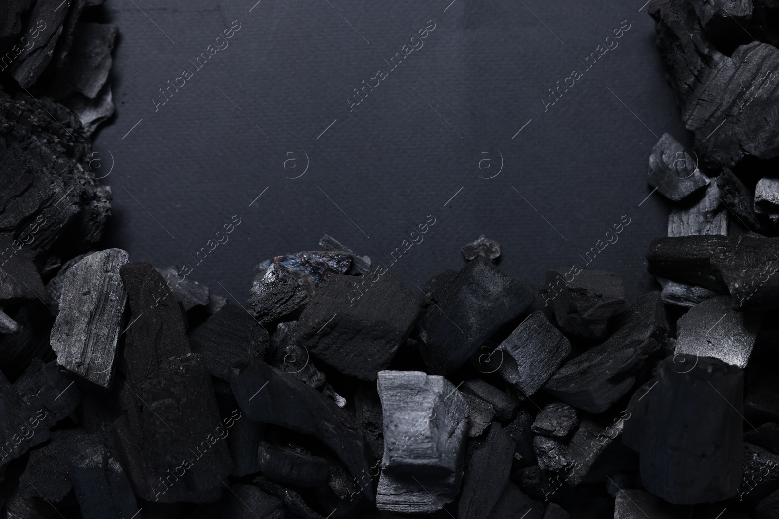 Pieces of black coals on grey background, top view. Space for text Photo of Pieces of black coals on grey background, top view. Space for text