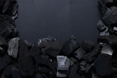 Photo of Pieces of black coals on grey background, top view. Space for text