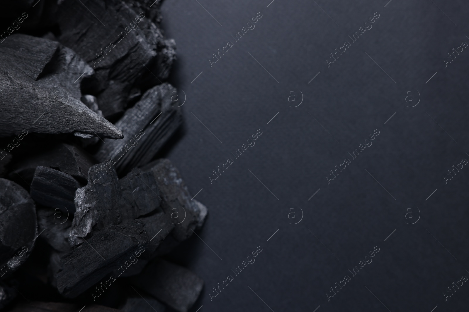 Pieces of black coals on grey background, top view. Space for text Photo of Pieces of black coals on grey background, top view. Space for text