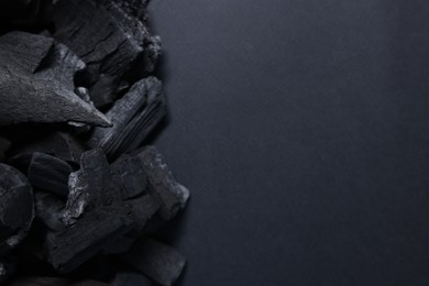 Photo of Pieces of black coals on grey background, top view. Space for text