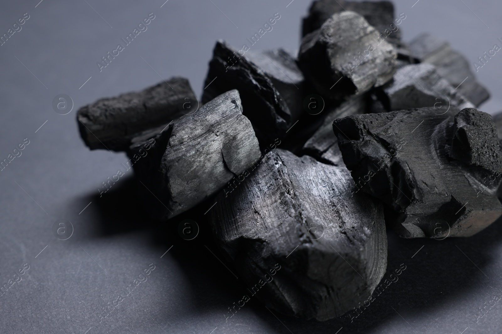 Pieces of black coals on grey table, closeup Photo of Pieces of black coals on grey table, closeup