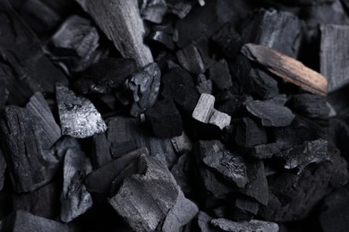 Photo of Pieces of black coals as background, top view