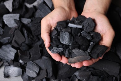 Photo of Man with black coals over pile, top view