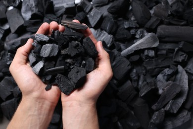 Photo of Man with black coals over pile, top view