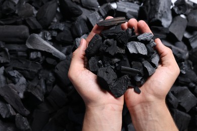Photo of Man with black coals over pile, top view
