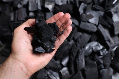 Photo of Man with black coals over pile, above view