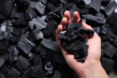Photo of Man with black coals over pile, above view