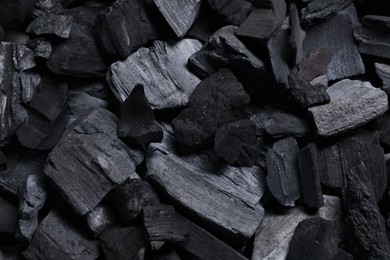 Photo of Pieces of black coals as background, top view