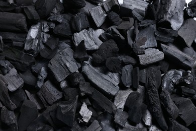 Photo of Pieces of black coals as background, top view