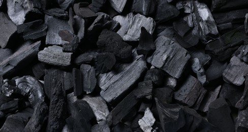 Photo of Pieces of black coals as background, top view