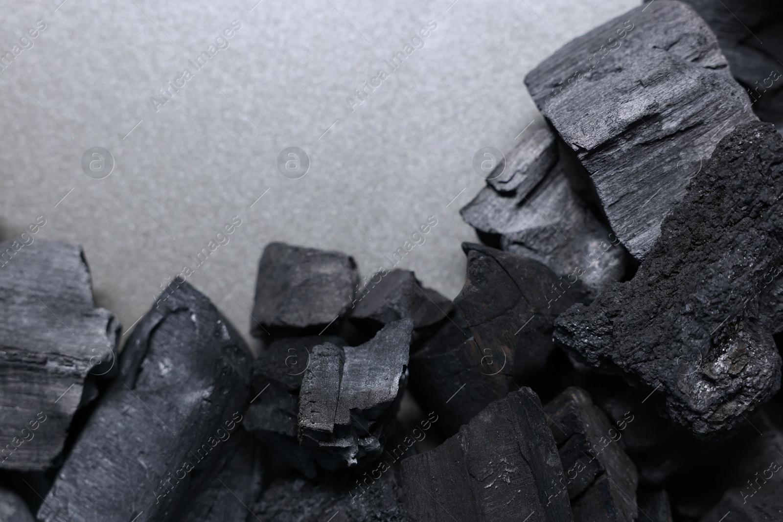 Pieces of black coals on grey table, top view. Space for text Photo of Pieces of black coals on grey table, top view. Space for text