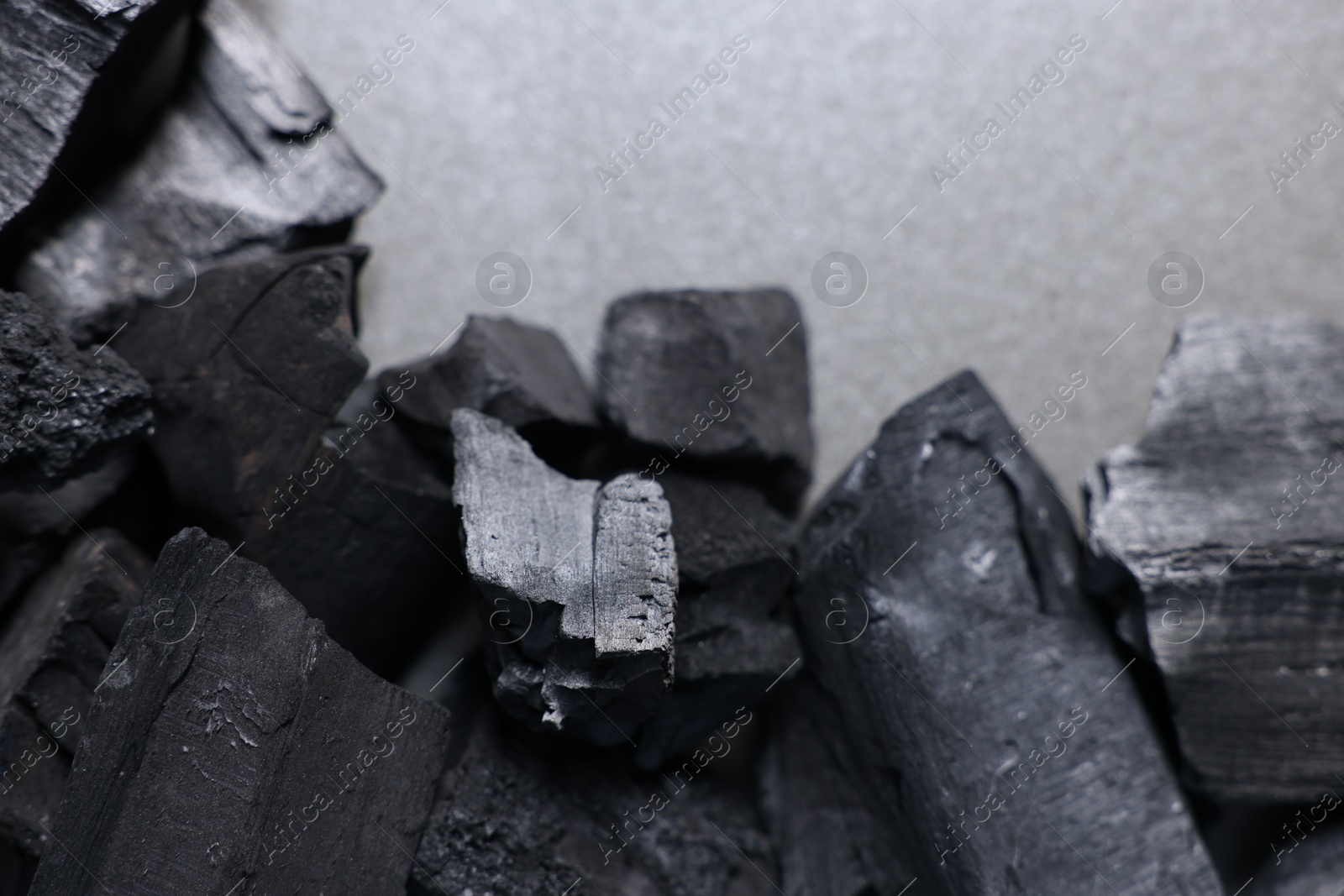 Pieces of black coals on grey table, top view Photo of Pieces of black coals on grey table, top view