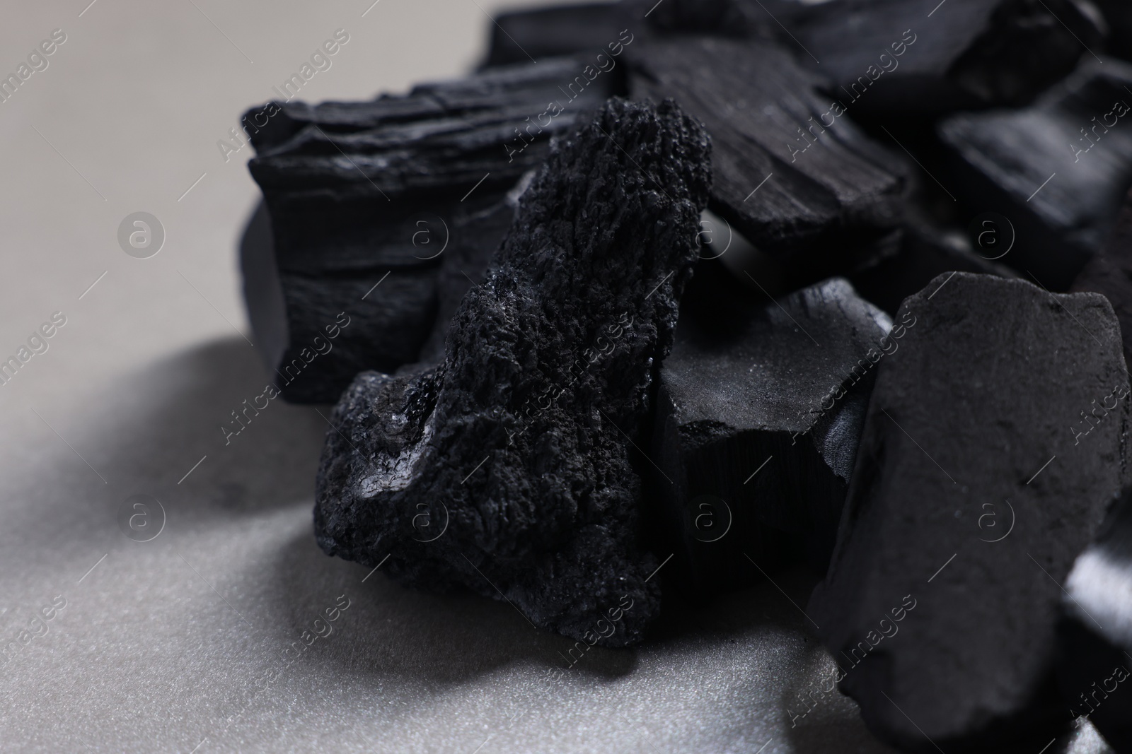 Pieces of black coals on grey table, closeup Photo of Pieces of black coals on grey table, closeup