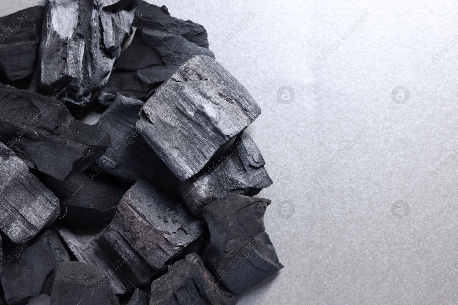 Pieces of black coals on grey table, top view. Space for text Photo of Pieces of black coals on grey table, top view. Space for text