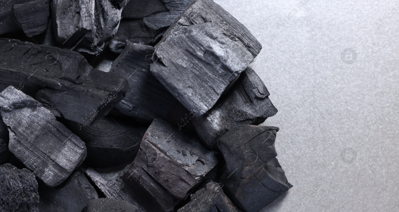 Pieces of black coals on grey table, top view. Space for text Photo of Pieces of black coals on grey table, top view. Space for text