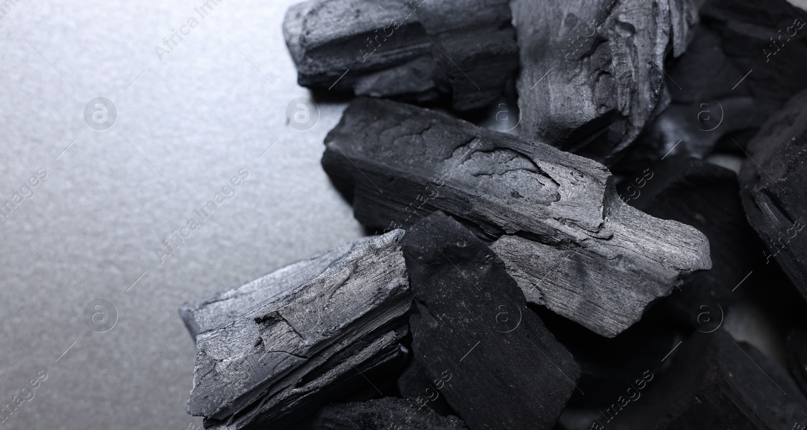 Pieces of black coals on table, above view. Space for text Photo of Pieces of black coals on table, above view. Space for text