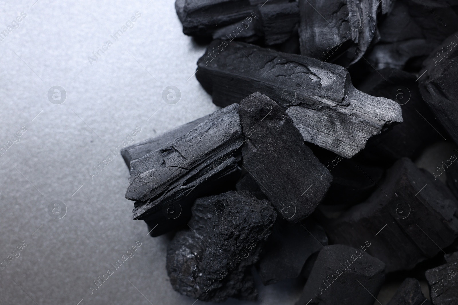 Pieces of black coals on table, top view. Space for text Photo of Pieces of black coals on table, top view. Space for text
