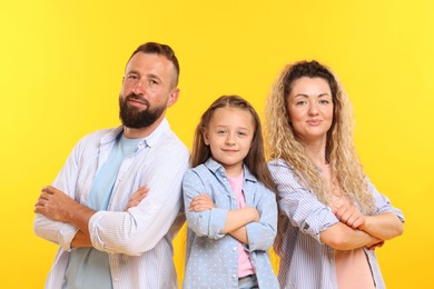 Photo of Portrait of family with crossed arms on yellow background