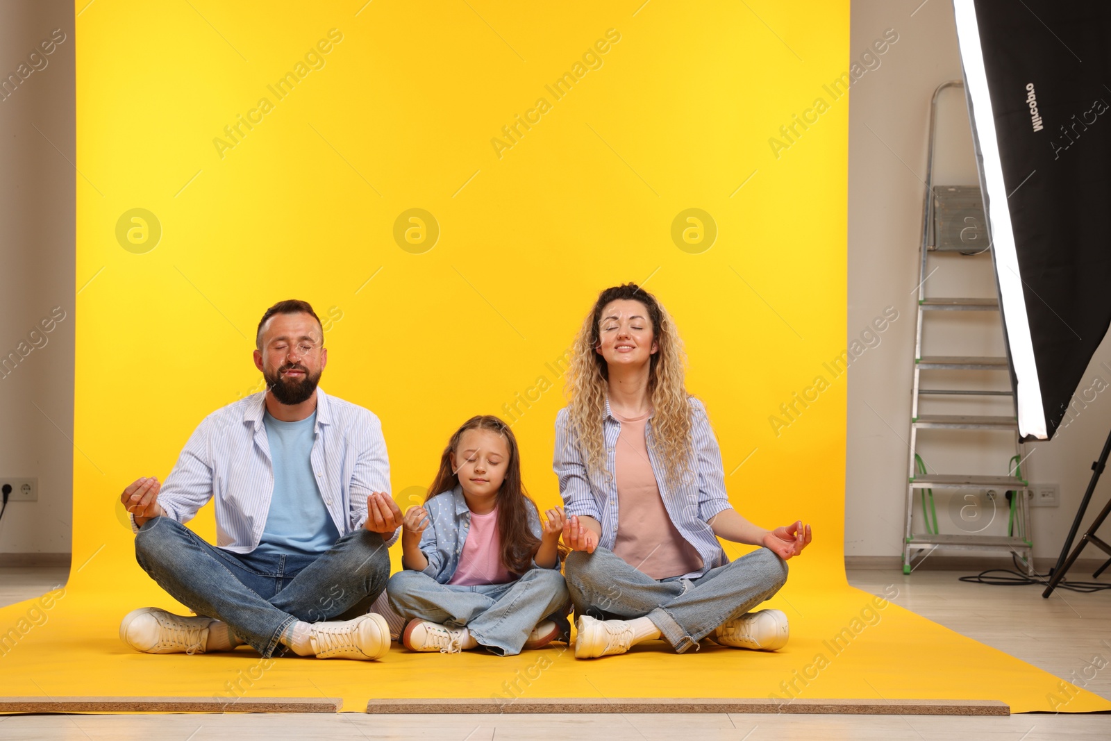 Happy family on yellow background. Space for text Photo of Happy family on yellow background. Space for text