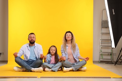 Photo of Happy family on yellow background. Space for text