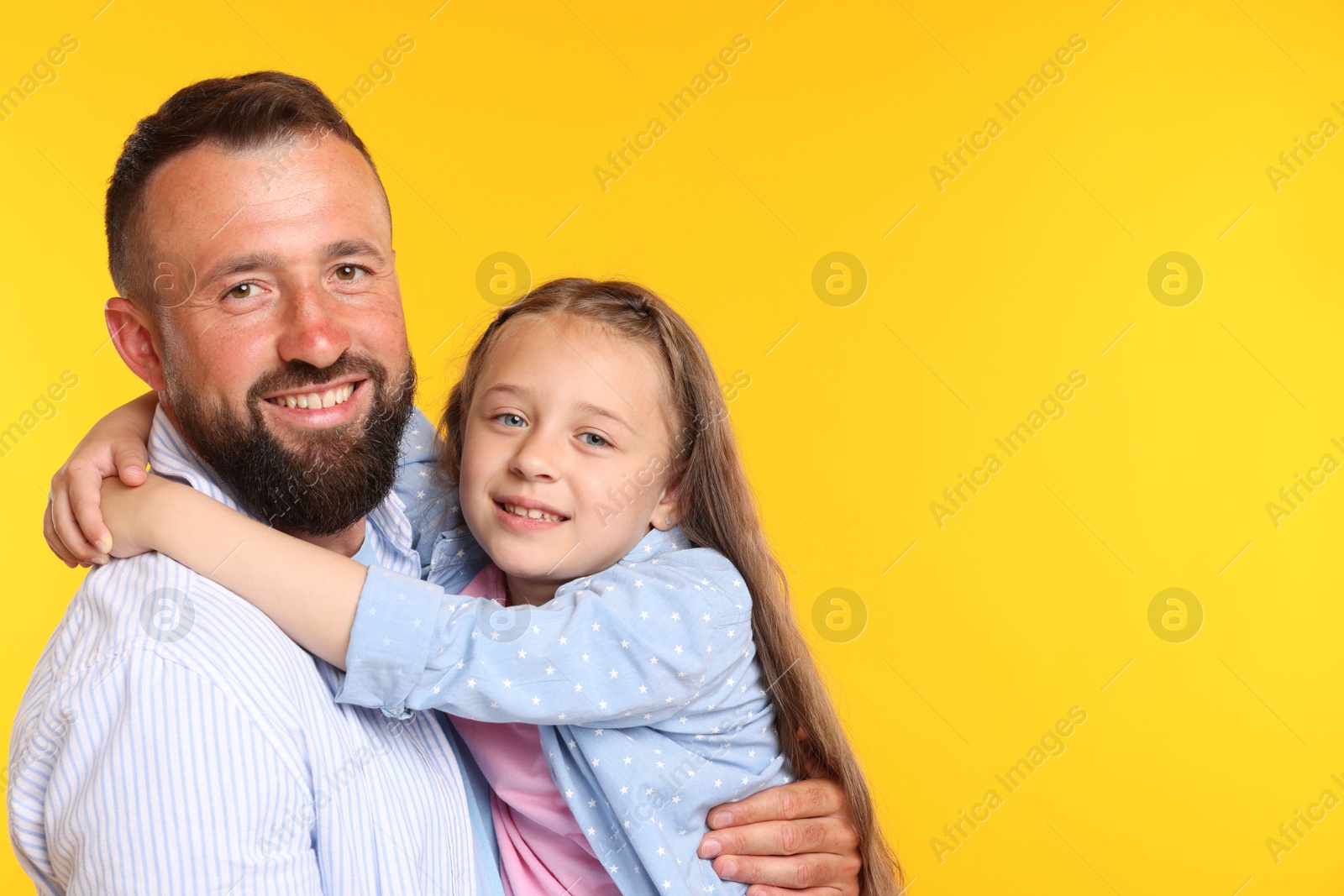 Family. Happy father and his daughter on yellow background. Space for text Photo of Family. Happy father and his daughter on yellow background. Space for text