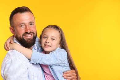 Photo of Family. Happy father and his daughter on yellow background. Space for text