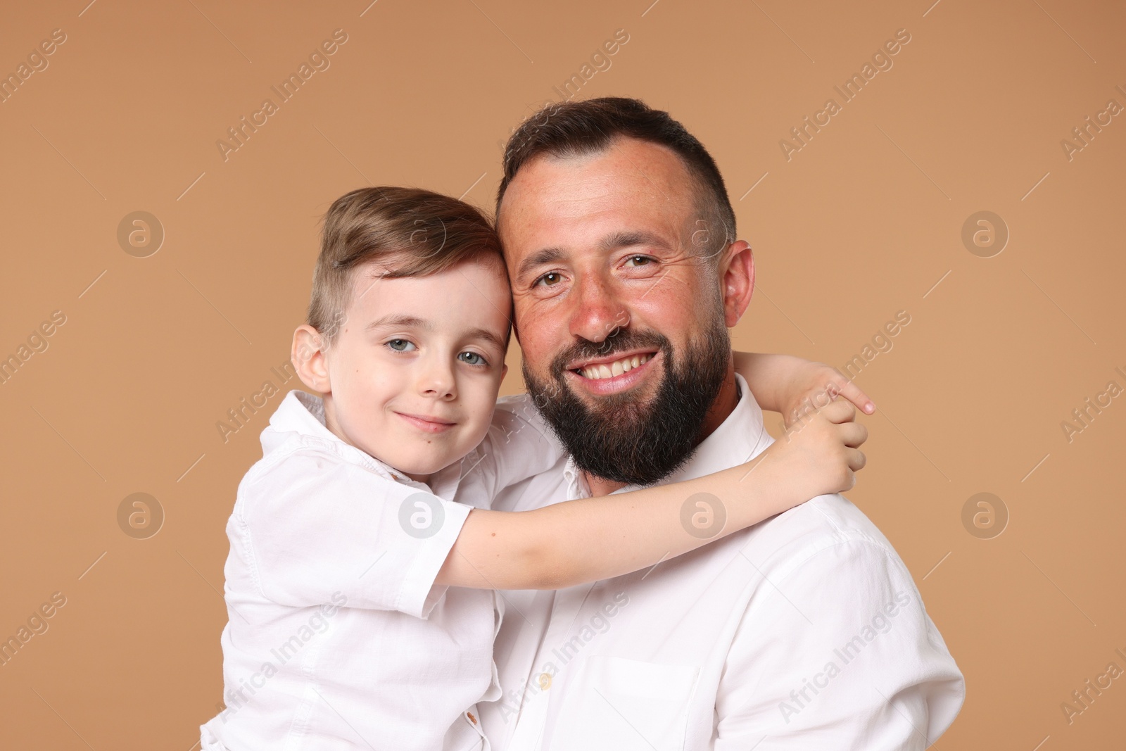 Family portrait of happy father and his son on beige background Photo of Family portrait of happy father and his son on beige background