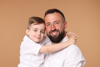 Photo of Family portrait of happy father and his son on beige background