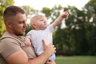 Photo of Dad with his cute newborn baby outdoors. Happy Father's Day