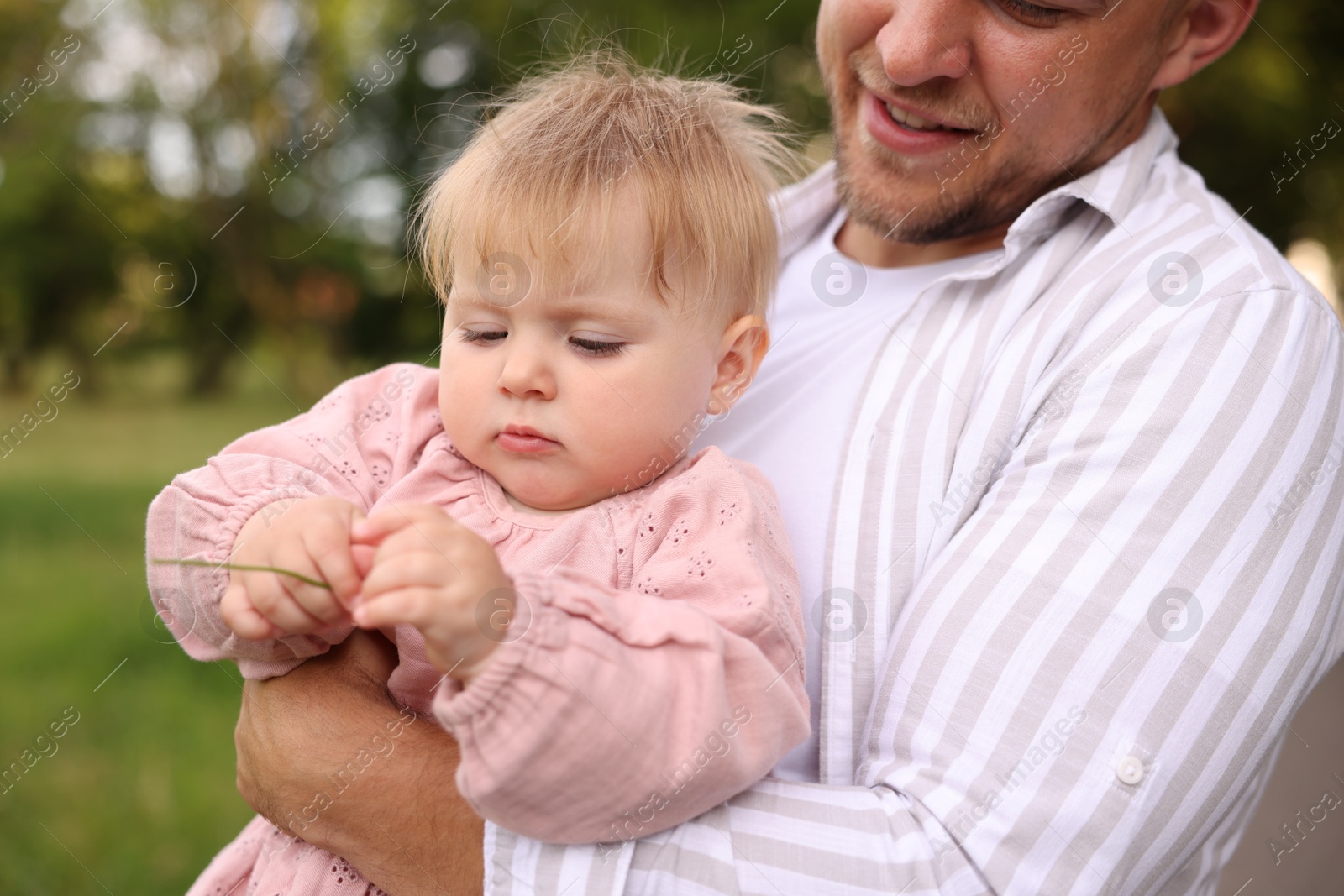 Smiling dad and his newborn girl outdoors, closeup. Happy Father's Day Photo of Smiling dad and his newborn girl outdoors, closeup. Happy Father's Day