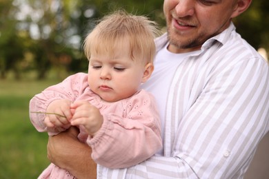 Photo of Smiling dad and his newborn girl outdoors, closeup. Happy Father's Day