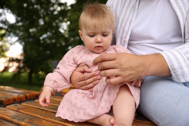 Photo of Dad and his newborn girl on bench outdoors, closeup. Happy Father's Day